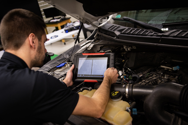 Mike under the hood in tech garage using scanner tool
